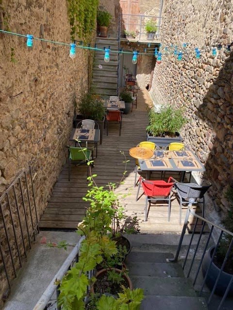 La cour intérieure du restaurant, terrasse à l'ombre entre les murs de pierre
